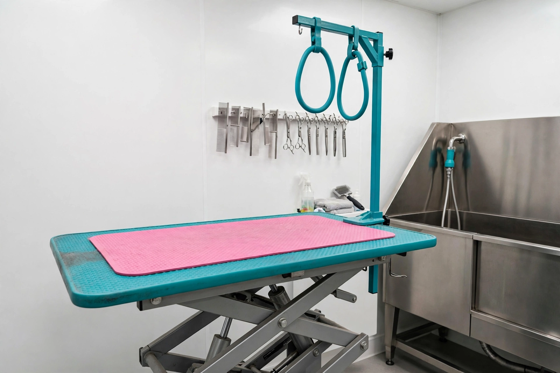 Hydraulic grooming table with a rubber mat and a wall-mounted comb and scissor rack